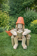 A girl or boy sitting on a chair reading a book